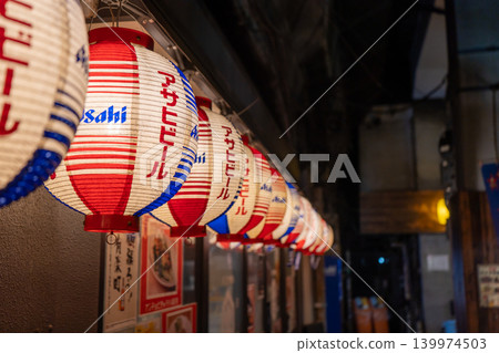 A nighttime entertainment district lined with lanterns; a retro Showa-era bar. A nighttime entertainment district lined with lanterns; a retro Showa-era bar. 139974503