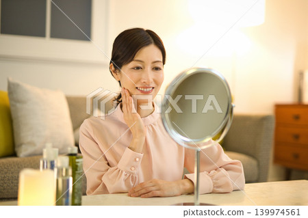 Middle-aged woman doing night skin care Middle-aged woman doing night skin care 139974561