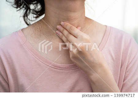Asian woman touching her neck and throat for thyroid gland problem. 139974717