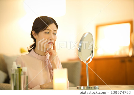 Middle-aged women who are concerned about skin problems during their nighttime skincare routine Middle-aged women who are concerned about skin problems during their nighttime skincare routine 139974793