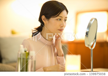 中年女性在夜間護膚過程中會擔心皮膚問題。 中年女性在夜間護膚過程中會擔心皮膚問題。 139975038