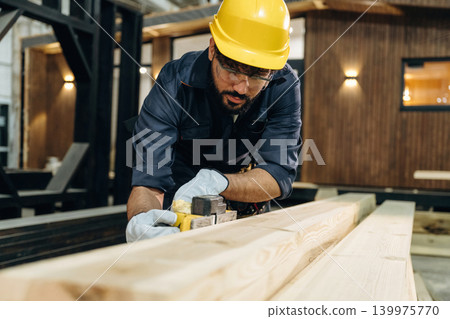 Polishing, focused. Male carpenter working with wooden materials in a professional workshop Polishing, focused. Male carpenter working with wooden materials in a professional workshop 139975770