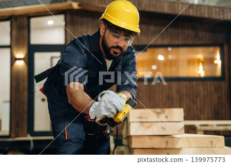 Polishing, focused. Male carpenter working with wooden materials in a professional workshop Polishing, focused. Male carpenter working with wooden materials in a professional workshop 139975773