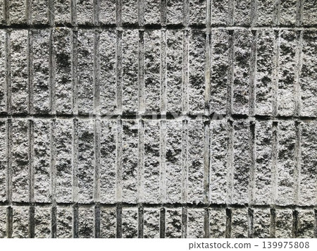 A background of a concrete block wall with uneven vertical lines. A background of a concrete block wall with uneven vertical lines. 139975808