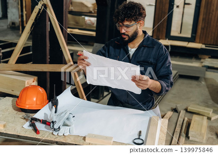 Male carpenter working with wooden materials in a professional workshop Male carpenter working with wooden materials in a professional workshop 139975846