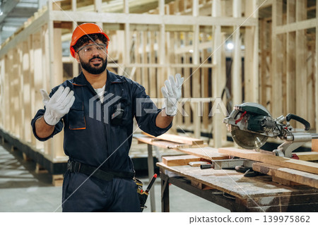 Employee is busy. Male carpenter working with wooden materials in a professional workshop Employee is busy. Male carpenter working with wooden materials in a professional workshop 139975862