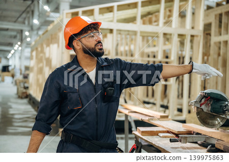 Employee is busy. Male carpenter working with wooden materials in a professional workshop 139975863