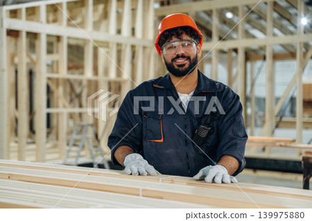 Skilled worker, front view. Portrait of a male carpenter posing in a woodworking workshop 139975880