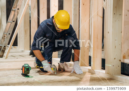 The right level is set up, sitting. Male carpenter working with wooden materials in a professional workshop The right level is set up, sitting. Male carpenter working with wooden materials in a professional workshop 139975909