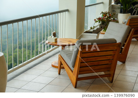 Balcony with wooden chairs and table looking out at hills Balcony with wooden chairs and table looking out at hills 139976090