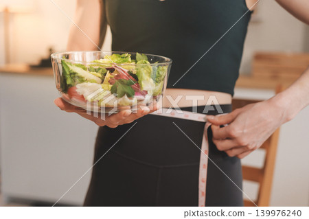 Woman preparing green smoothie in bright kitchen with fresh fruits and vegetables, healthy eating lifestyle moment in natural daylight Woman preparing green smoothie in bright kitchen with fresh fruits and vegetables, healthy eating lifestyle moment in natural daylight 139976240
