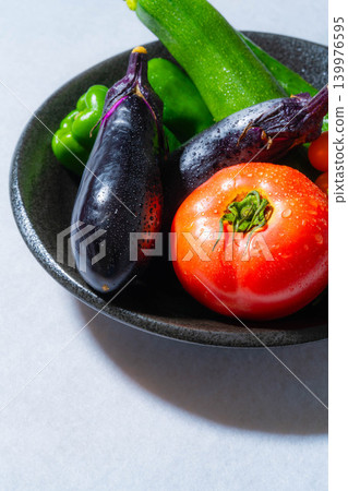 Assortment of fresh, dewy summer vegetables: tomatoes, eggplant, cucumbers, zucchini, and peppers 139976595