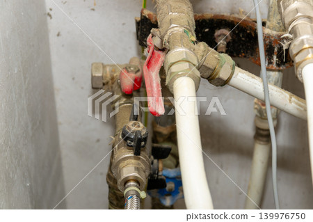 Close-Up Of Plumbing Pipes And Valves Under Sink With White Plastic Tubing And Fittings Close-Up Of Plumbing Pipes And Valves Under Sink With White Plastic Tubing And Fittings 139976750