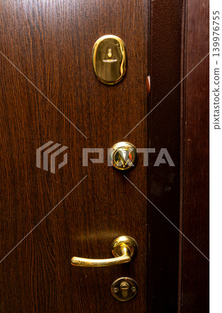 Brass Door Handle And Lock On Wooden Entry Door Showing Closeup Detail And Home Security Brass Door Handle And Lock On Wooden Entry Door Showing Closeup Detail And Home Security 139976755