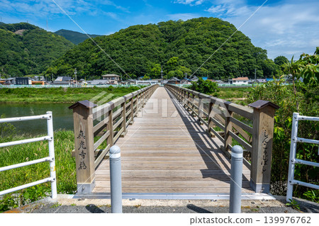The fresh green leaves on the mountains across the river have faded, and the greenery has deepened at Shinkoji Bridge. 139976762