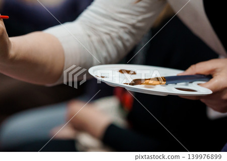 Artist Hands Holding White Palette and Paintbrush with Brown Watercolor Paints in Studio Artist Hands Holding White Palette and Paintbrush with Brown Watercolor Paints in Studio 139976899