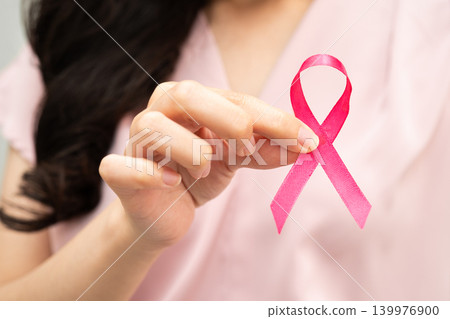 Asian woman with pink ribbon, World Breast Cancer Day at October. Asian woman with pink ribbon, World Breast Cancer Day at October. 139976900