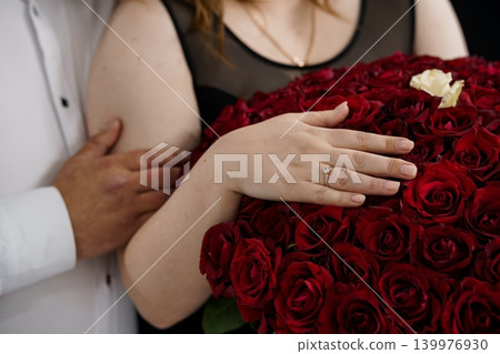 Close up of Woman with Diamond Engagement Ring Holding Large Bouquet of Red Roses Close up of Woman with Diamond Engagement Ring Holding Large Bouquet of Red Roses 139976930