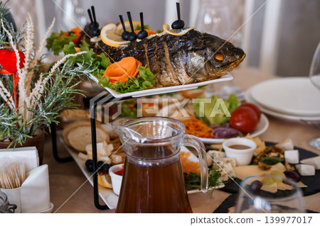 Roasted Whole Fish with Lemon and Olives Served on a Multi-Tiered Buffet Platter at a Festive Dinner Roasted Whole Fish with Lemon and Olives Served on a Multi-Tiered Buffet Platter at a Festive Dinner 139977017