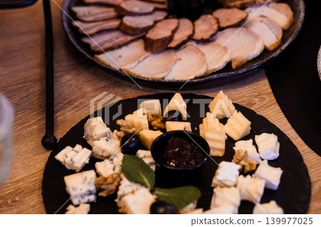 Gourmet Cheese and Charcuterie Platter with Sliced Meats and Blue Cheese on Dark Slate Boards Gourmet Cheese and Charcuterie Platter with Sliced Meats and Blue Cheese on Dark Slate Boards 139977025
