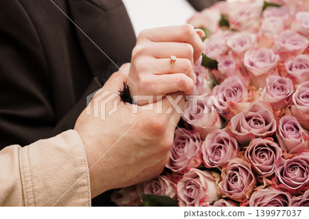 Couple Holding Hands with Diamond Engagement Ring and Pink Roses Bouquet Romantic Concept Couple Holding Hands with Diamond Engagement Ring and Pink Roses Bouquet Romantic Concept 139977037