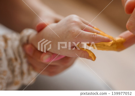 Close Up of Hands Kneading Yellow Modeling Clay or Dough for Creative Art and Sensory Play 139977052