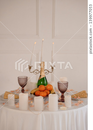 Elegant Champagne Celebration with Candelabra, Oranges and Fruit on White Tablecloth Elegant Champagne Celebration with Candelabra, Oranges and Fruit on White Tablecloth 139977053
