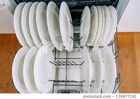 open dishwasher with clean white plates. High quality photo open dishwasher with clean white plates. High quality photo 139977281