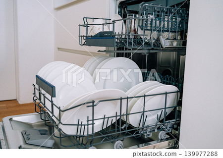 open dishwasher with clean white plates. High quality photo open dishwasher with clean white plates. High quality photo 139977288