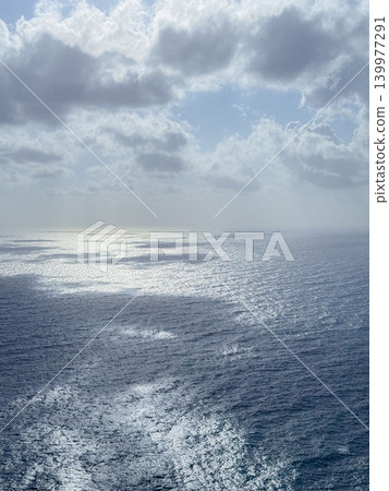 Majestic view of the ocean with the sun reflecting off the water beneath a sky filled with fluffy clouds, creating a serene and breathtaking seascape perfect for relaxation and inspiration Majestic view of the ocean with the sun reflecting off the water beneath a sky filled with fluffy clouds, creating a serene and breathtaking seascape perfect for relaxation and inspiration 139977291
