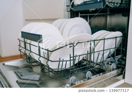 open dishwasher with clean white plates. High quality photo open dishwasher with clean white plates. High quality photo 139977317