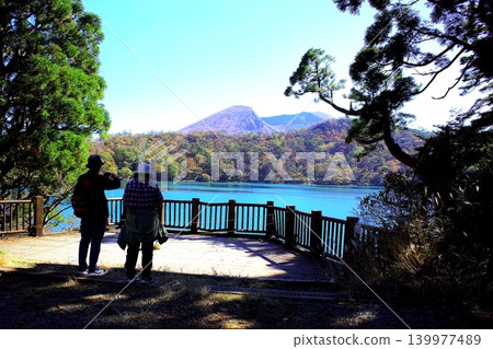 An elderly couple reminisces in front of Rokukannon-goike Pond in Ebino Plateau, Miyazaki Prefecture. An elderly couple reminisces in front of Rokukannon-goike Pond in Ebino Plateau, Miyazaki Prefecture. 139977489