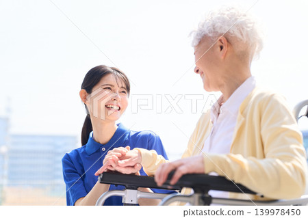 Asian caregiver smiles and converses with senior citizens. Asian caregiver smiles and converses with senior citizens. 139978450