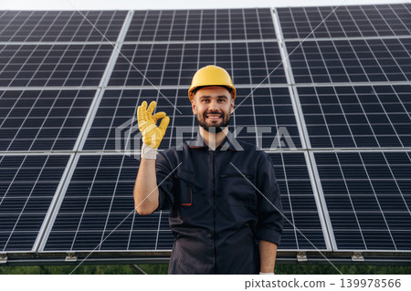 Everything is fine, hands gesture. Male solar engineer examining photovoltaic panels at a power station Everything is fine, hands gesture. Male solar engineer examining photovoltaic panels at a power station 139978566