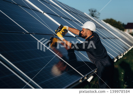 Male solar engineer examining photovoltaic panels at a power station 139978584