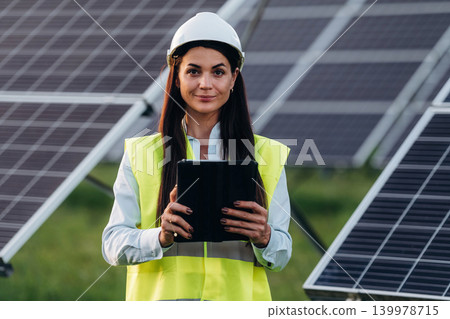 Female solar engineer inspecting photovoltaic panels during outdoor maintenance work Female solar engineer inspecting photovoltaic panels during outdoor maintenance work 139978715