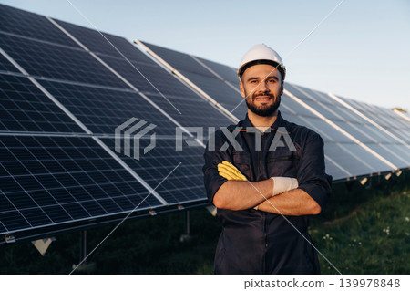 Arms crossed, standing and posing. Male solar engineer examining photovoltaic panels at a power station 139978848