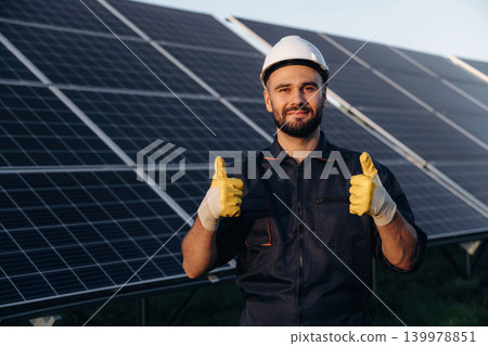 Thumb up gesture. Male solar engineer examining photovoltaic panels at a power station 139978851