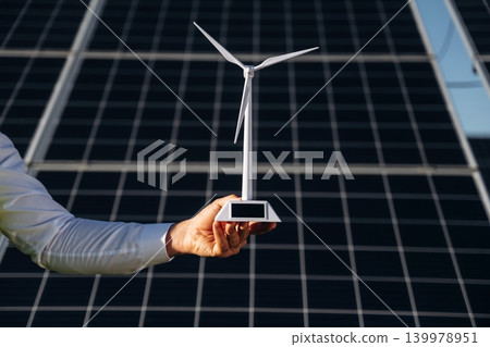 Male solar engineer examining photovoltaic panels at a power station Male solar engineer examining photovoltaic panels at a power station 139978951