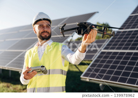 Drone specialist. Male solar engineer examining photovoltaic panels at a power station Drone specialist. Male solar engineer examining photovoltaic panels at a power station 139978962
