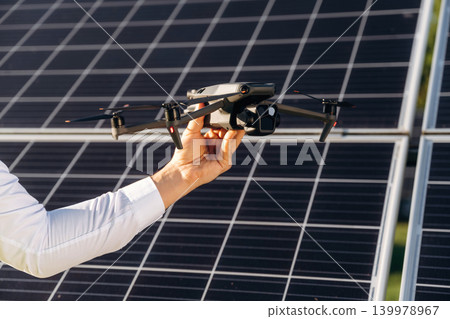 Drone specialist. Male solar engineer examining photovoltaic panels at a power station Drone specialist. Male solar engineer examining photovoltaic panels at a power station 139978967