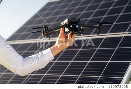 Modern drone conception, control. Male solar engineer examining photovoltaic panels at a power station Modern drone conception, control. Male solar engineer examining photovoltaic panels at a power station 139978968