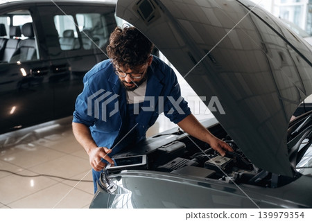 Experienced mechanic performing maintenance in workshop Experienced mechanic performing maintenance in workshop 139979354