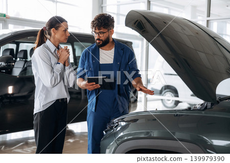 Expertise, explaining the stuff. Technical inspection explained to customer indoors Expertise, explaining the stuff. Technical inspection explained to customer indoors 139979390