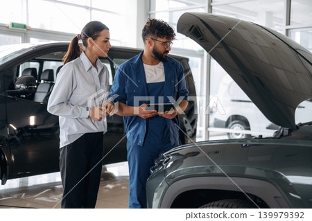 Expertise, explaining the stuff. Technical inspection explained to customer indoors Expertise, explaining the stuff. Technical inspection explained to customer indoors 139979392