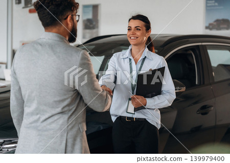Nice to meet you, handshake. Business consultation between car dealer and buyer in showroom Nice to meet you, handshake. Business consultation between car dealer and buyer in showroom 139979400