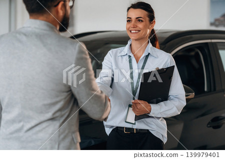 Nice to meet you, handshake. Business consultation between car dealer and buyer in showroom Nice to meet you, handshake. Business consultation between car dealer and buyer in showroom 139979401