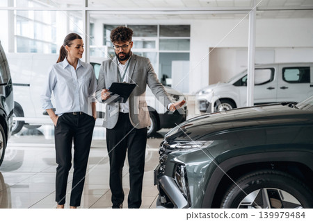 Business consultation between car dealer and buyer in showroom Business consultation between car dealer and buyer in showroom 139979484
