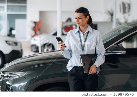 Front view. Successful automotive consultant standing near car interior Front view. Successful automotive consultant standing near car interior 139979570