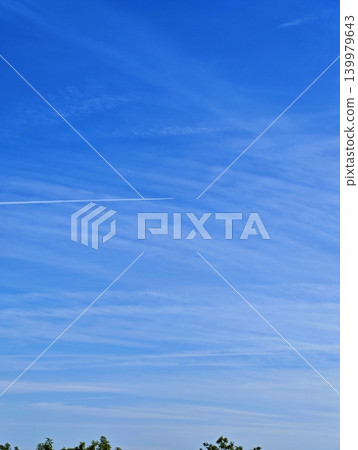 A thin, long condensation trail left by a jet airplane across a clear, vibrant blue gradient sky, representing travel, aviation, and connectivity. A thin, long condensation trail left by a jet airplane across a clear, vibrant blue gradient sky, representing travel, aviation, and connectivity. 139979643